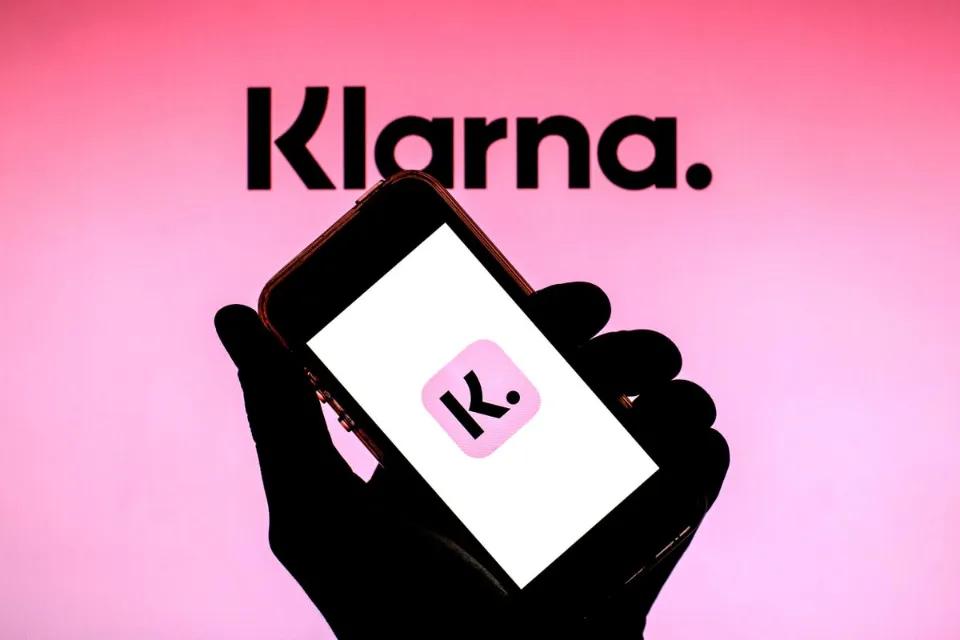 A phone with the Klarna logo and a pink background with the word klarna on top